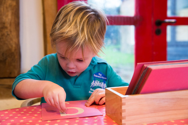 Boy with letter on paper (Grantham Farm Montessori School)
