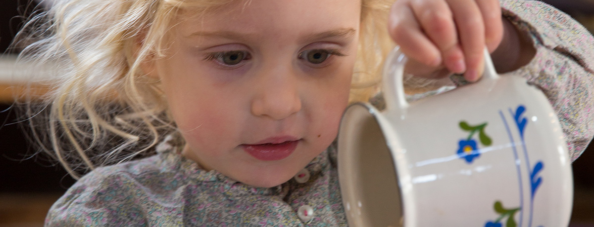 Girl pouring from a jug (Grantham Farm Montessori School)