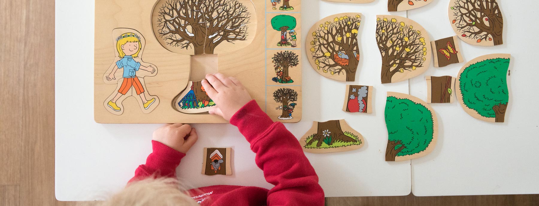 Child putting together a large illustrated puzzle (Grantham Farm Montessori School)